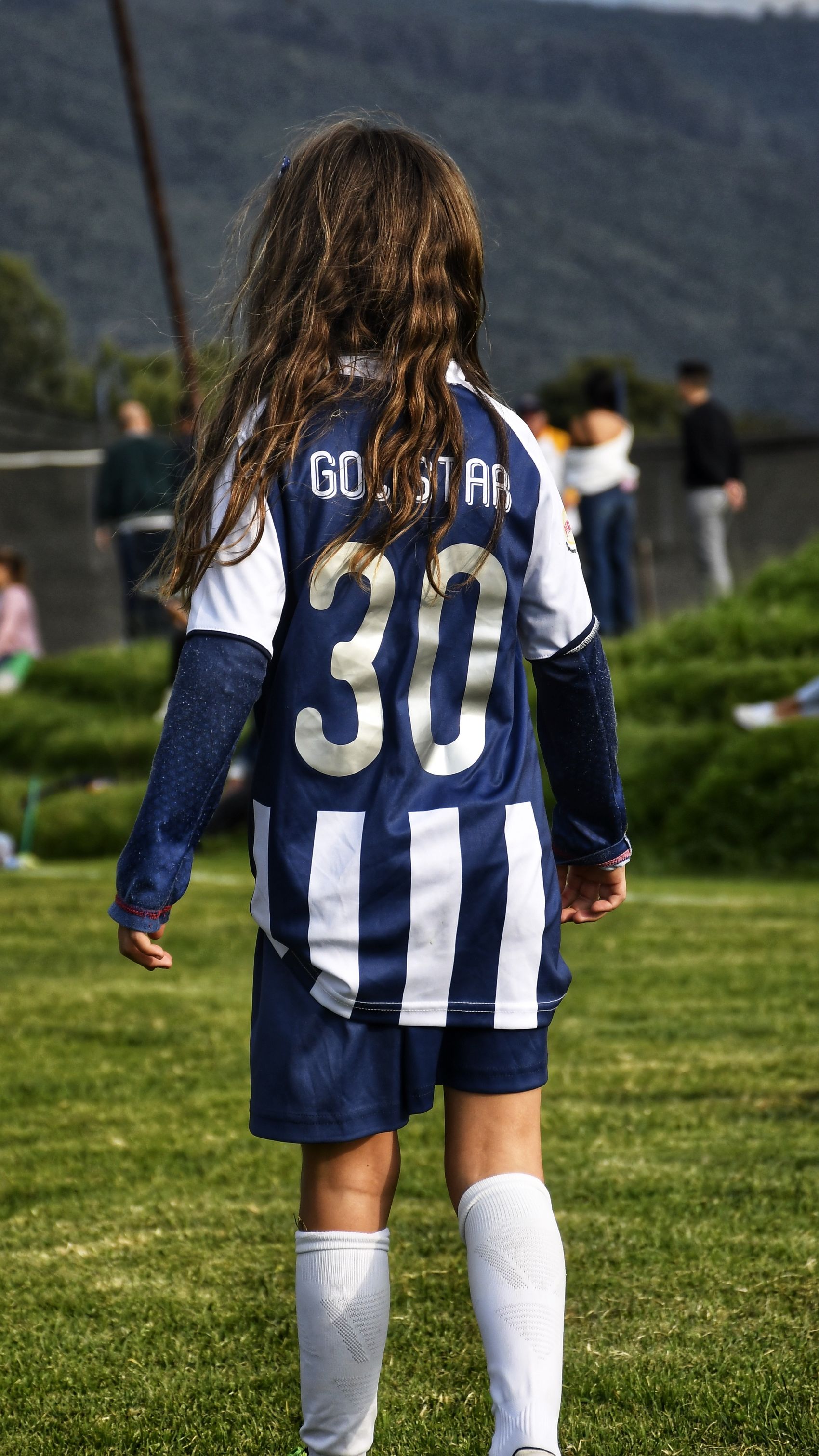 Mädchen mit Rückennummer 30 steht am Spielfeldrand